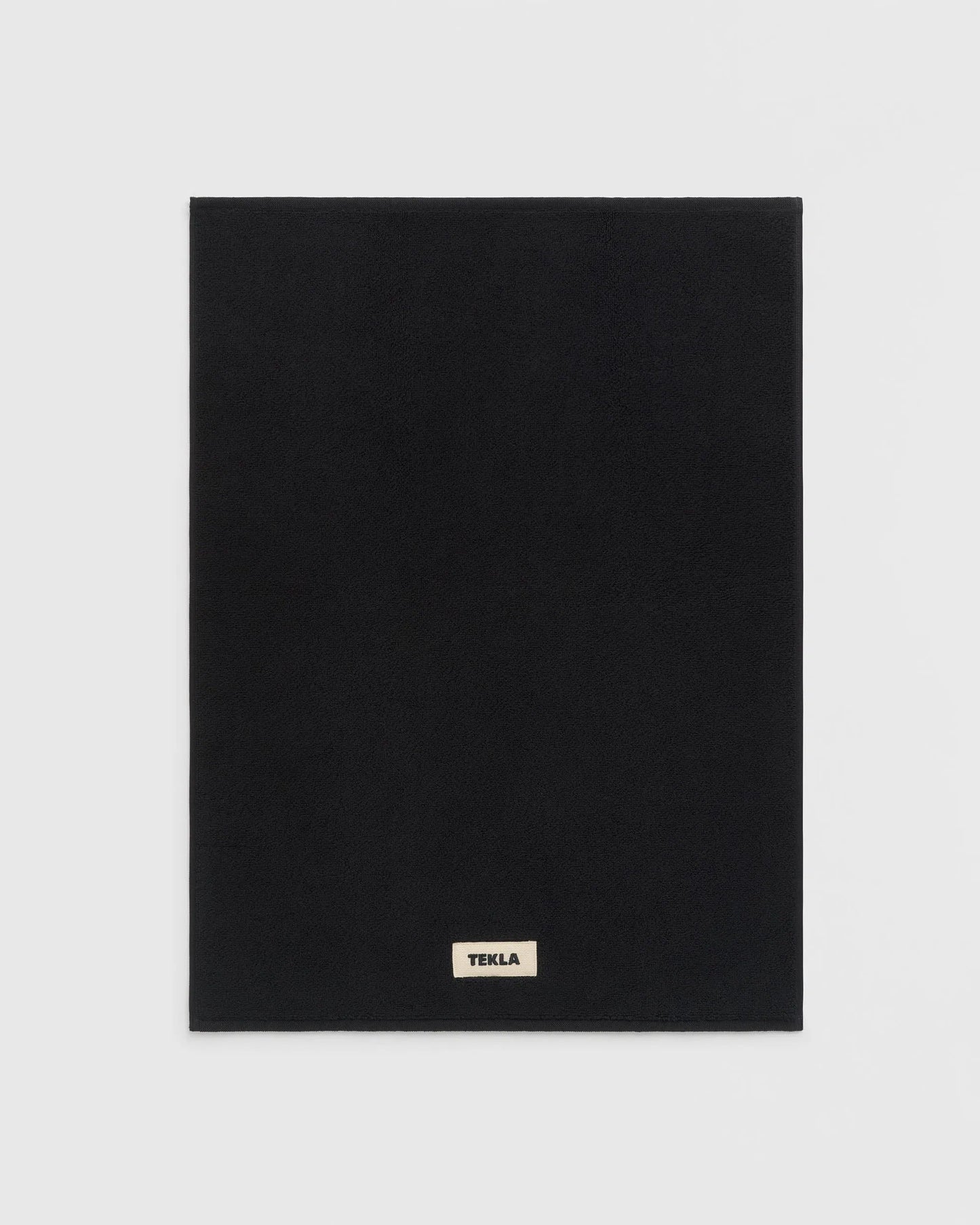 Black square product with 'Tekla' logo on a light gray background