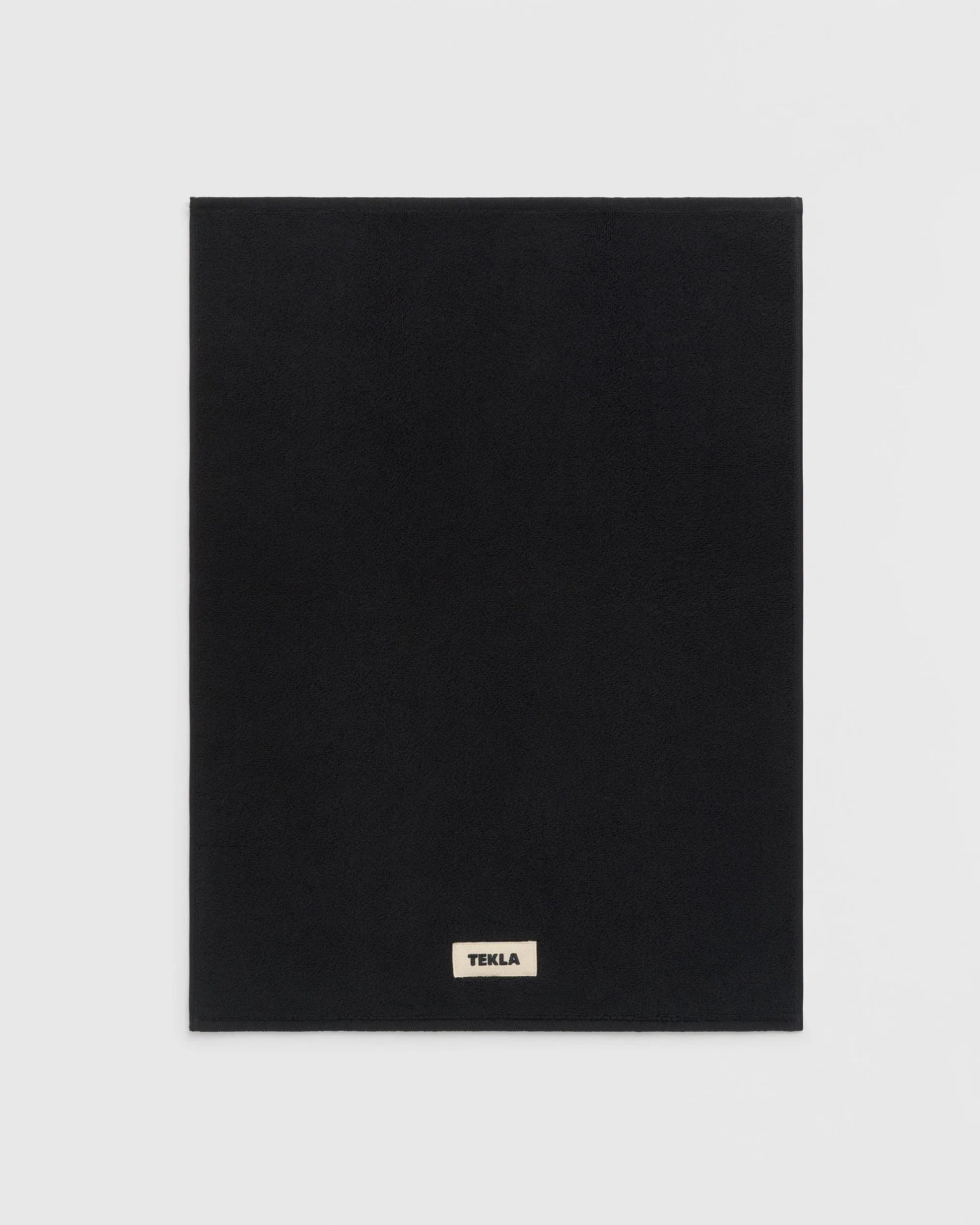 Black square product with 'Tekla' logo on a light gray background