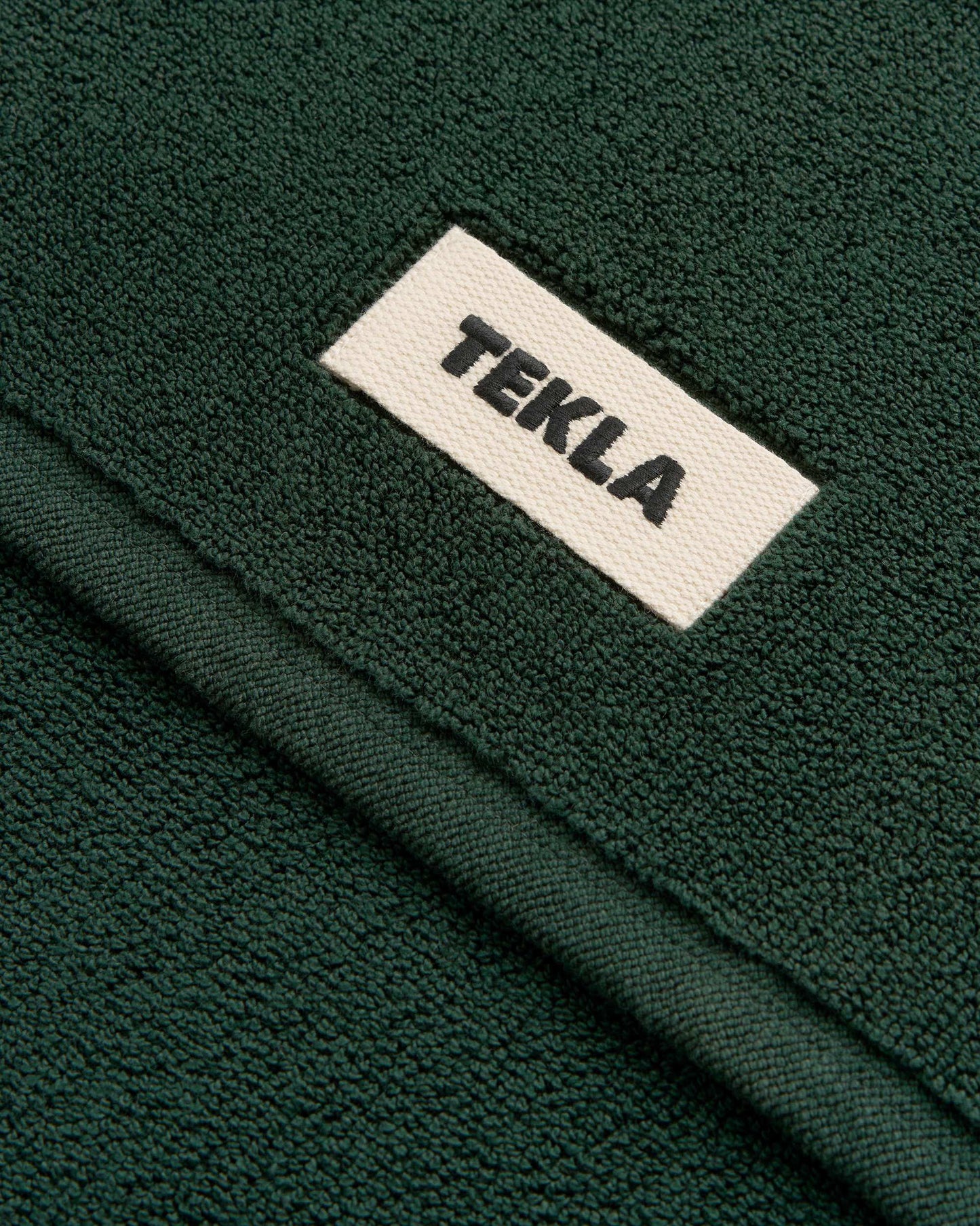 Close-up of a green fabric with a 'Tekla' label.