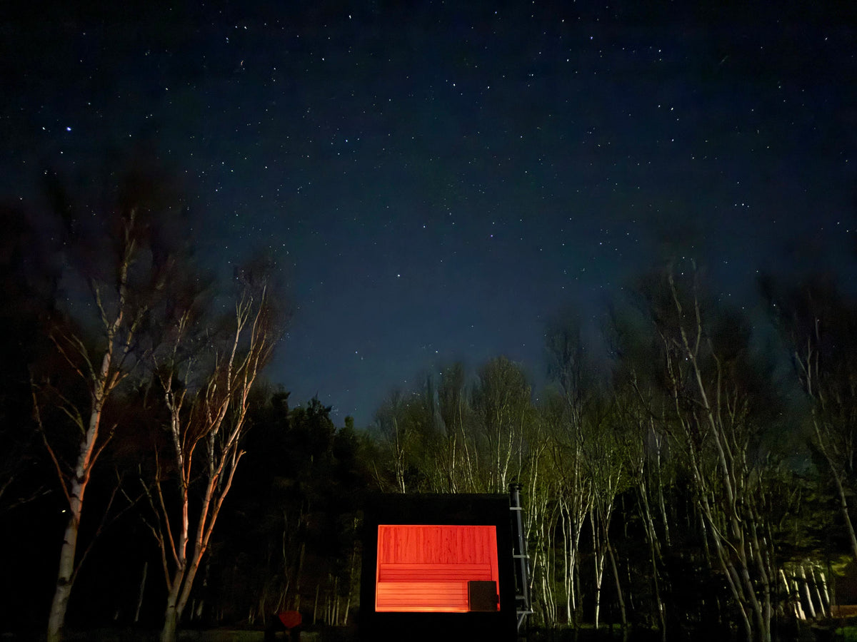A Sip sauna glowing at night under the stars