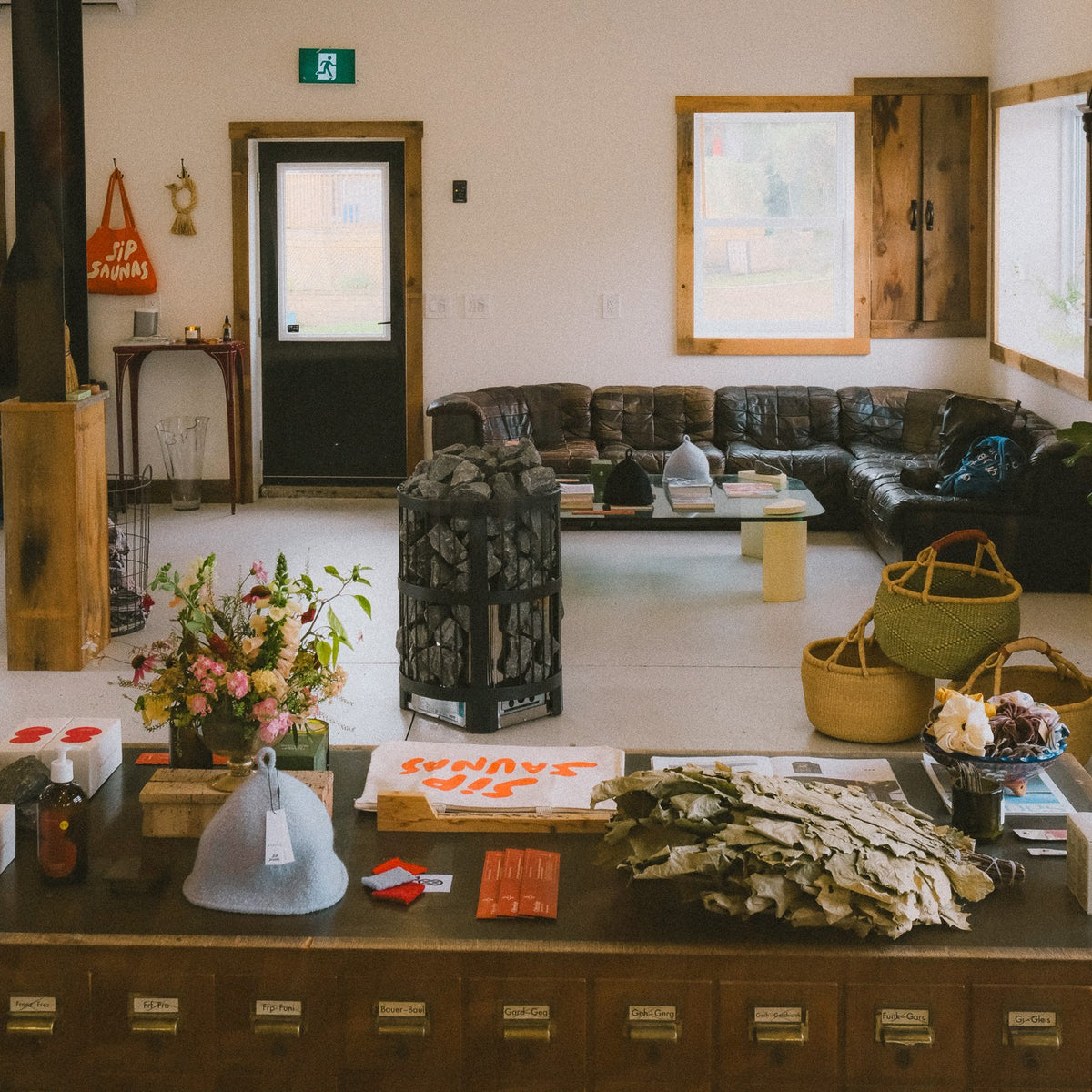 The Sip Saunas showroom in Bloomfield, with a Harvia heater, a leather sofa and sauna goods on the counter